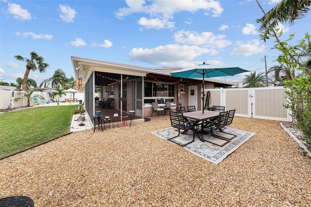 rear view of property with a yard, a patio area, and a sunroom