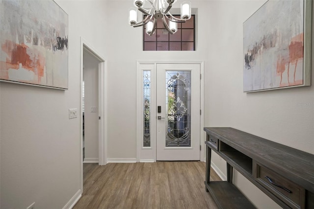 foyer entrance with an inviting chandelier and hardwood / wood-style flooring