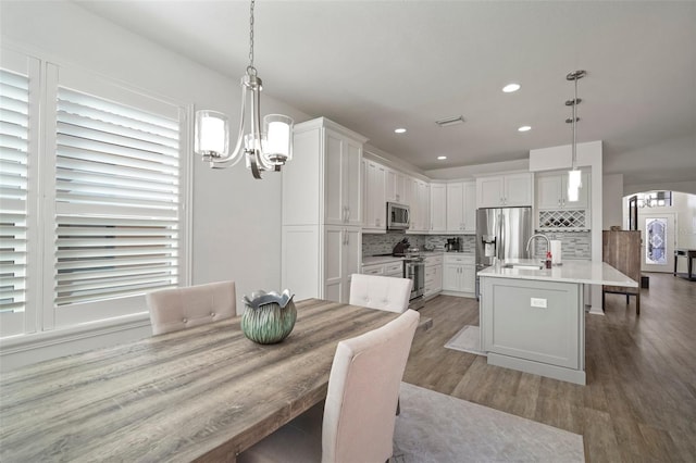 dining area featuring a wealth of natural light, sink, and hardwood / wood-style flooring