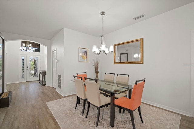 dining area featuring hardwood / wood-style flooring and a notable chandelier