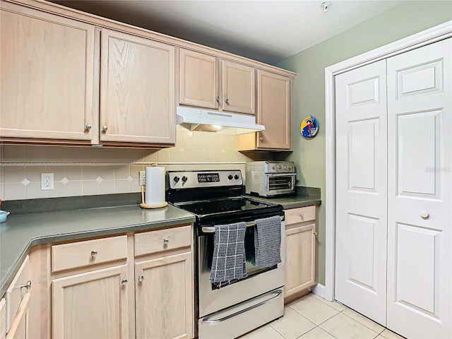 kitchen with stainless steel electric stove, backsplash, light brown cabinetry, and light tile patterned floors