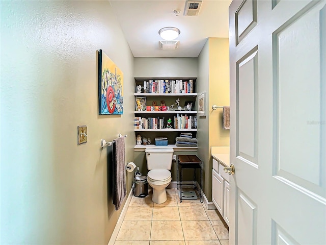 bathroom featuring tile patterned flooring, vanity, and toilet