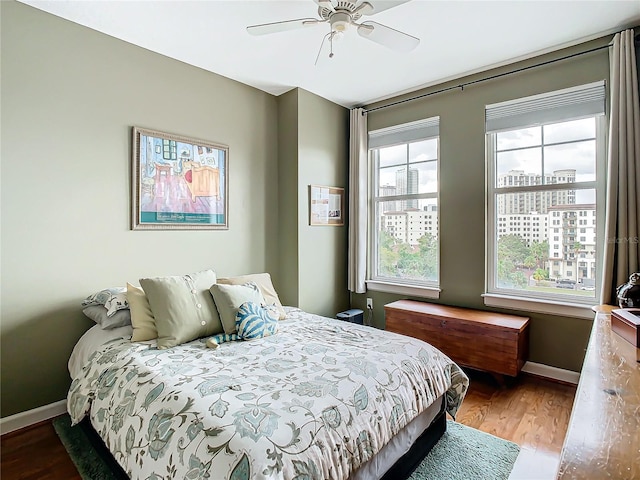 bedroom featuring multiple windows, ceiling fan, and hardwood / wood-style floors