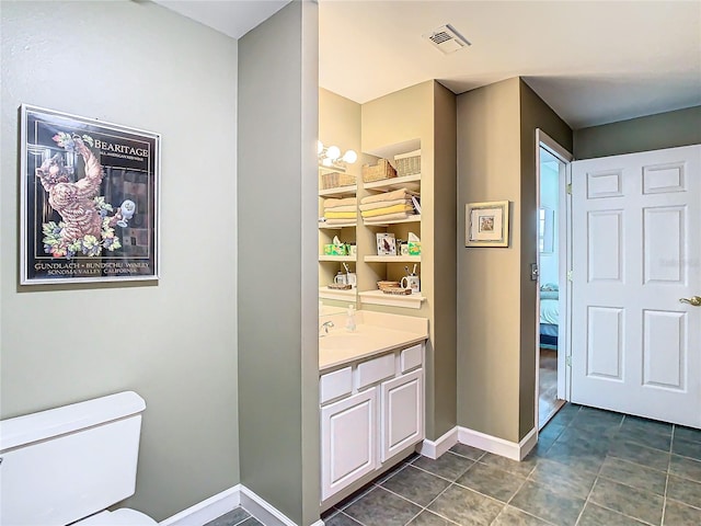 bathroom with tile patterned flooring, vanity, and toilet