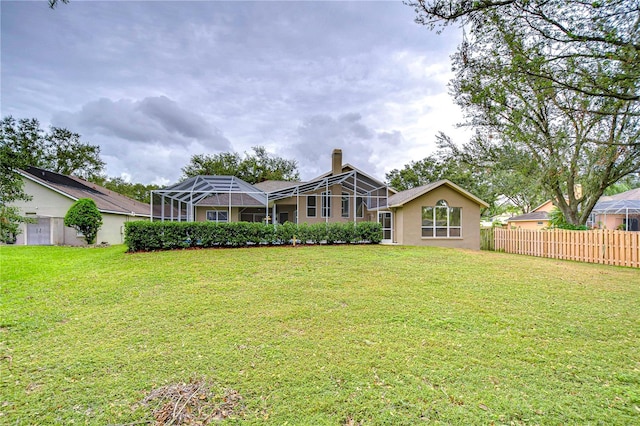 back of property with a lanai and a lawn