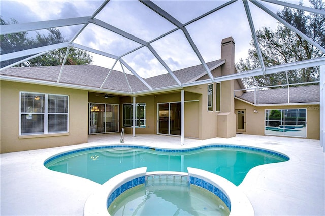 view of swimming pool with ceiling fan, a patio, a lanai, and an in ground hot tub