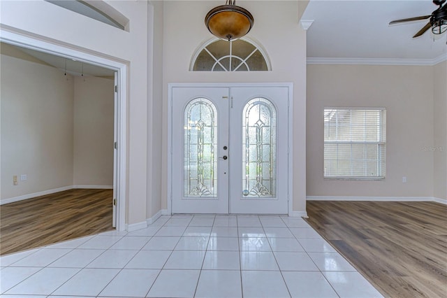 foyer featuring ornamental molding, ceiling fan, french doors, and light hardwood / wood-style floors