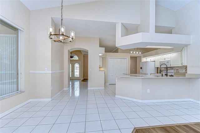 kitchen with white appliances, white cabinetry, and high vaulted ceiling