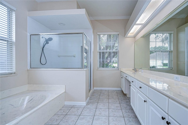 bathroom featuring a skylight, vanity, shower with separate bathtub, and tile patterned floors