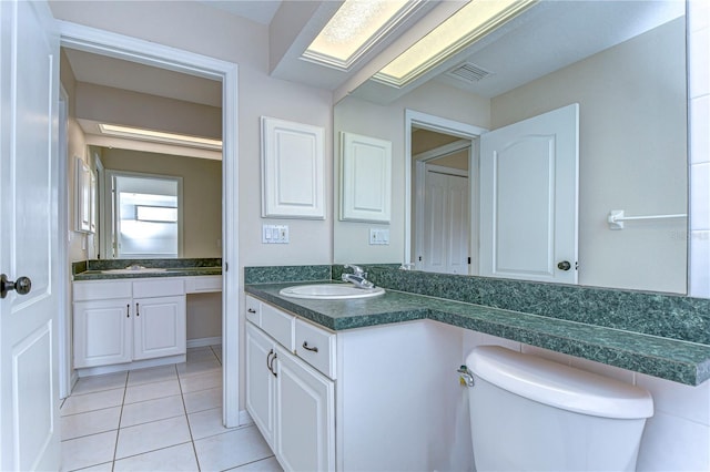 bathroom featuring vanity, tile patterned floors, and toilet