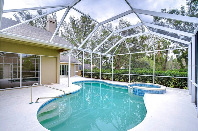 view of pool featuring glass enclosure, a patio, and an in ground hot tub