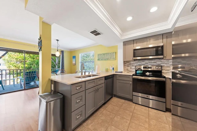 kitchen with kitchen peninsula, a wealth of natural light, sink, and appliances with stainless steel finishes