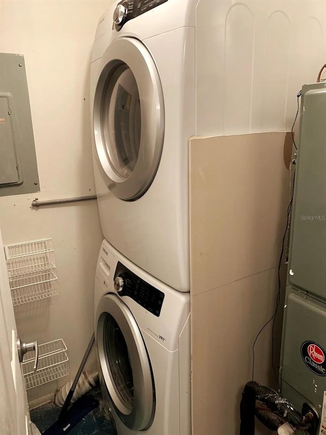 laundry area with stacked washer and dryer and electric panel