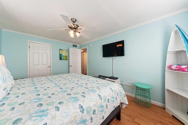 bedroom with a closet, light wood-type flooring, ceiling fan, and crown molding