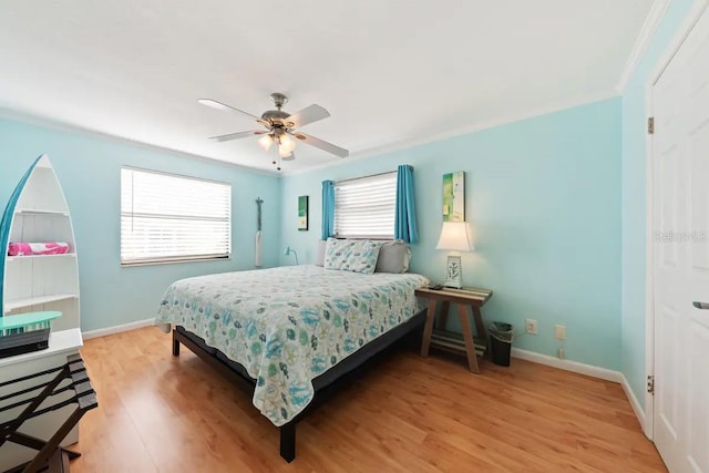 bedroom with ornamental molding, light hardwood / wood-style floors, and ceiling fan