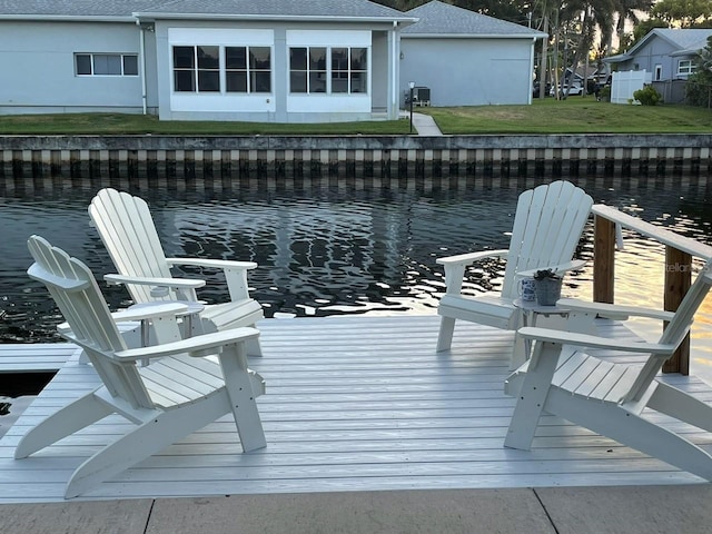 view of dock featuring a water view and a yard