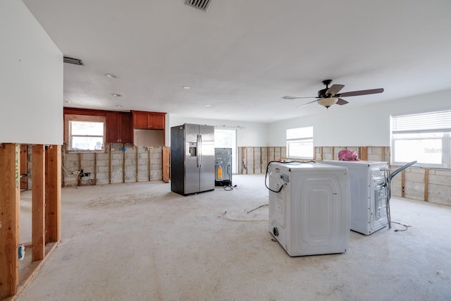 interior space featuring stainless steel refrigerator with ice dispenser, ceiling fan, and washer / clothes dryer