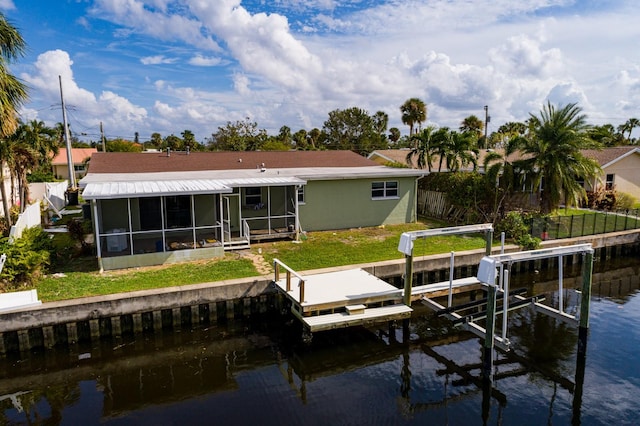 dock area with a water view and a lawn