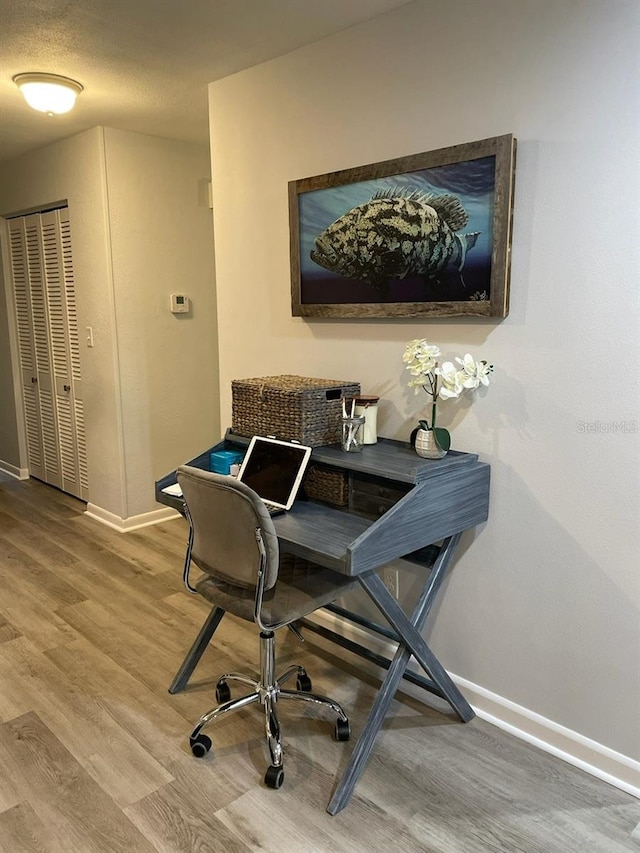 home office featuring hardwood / wood-style floors and a textured ceiling