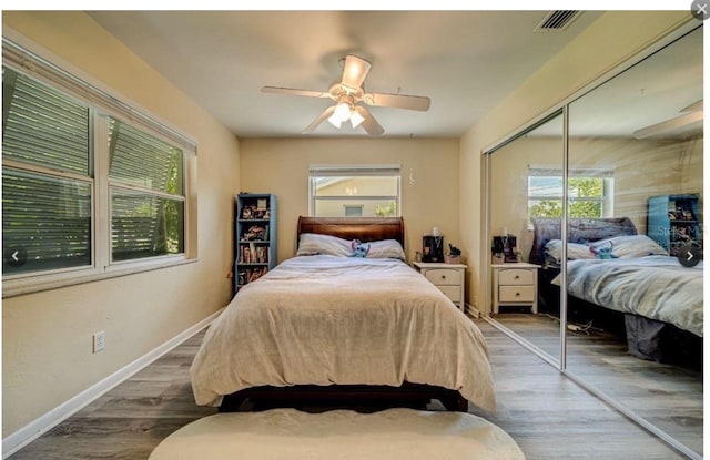 bedroom featuring hardwood / wood-style flooring, ceiling fan, and a closet