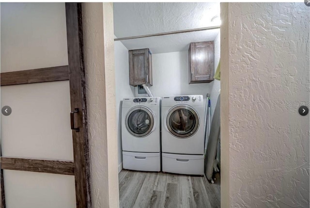 laundry area with light hardwood / wood-style flooring, cabinets, and independent washer and dryer