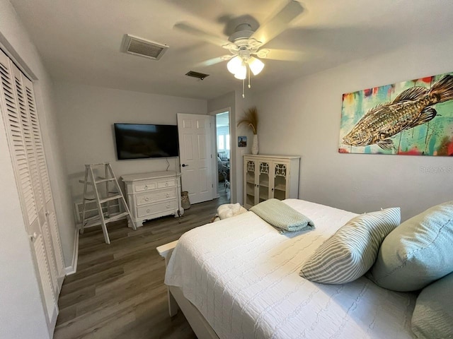 bedroom with ceiling fan, a closet, wood finished floors, and visible vents