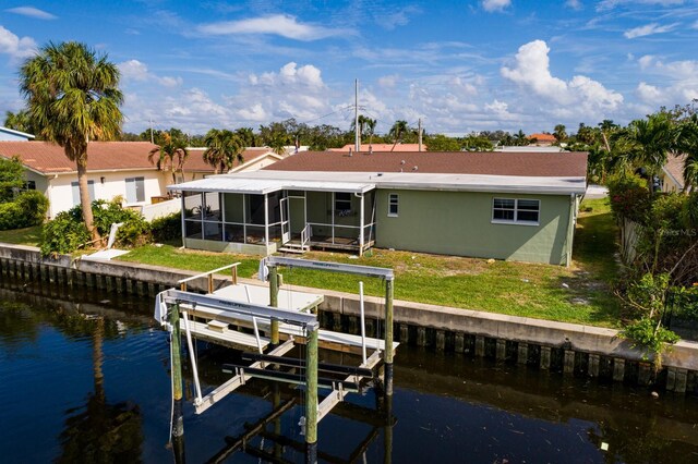 view of dock with a lawn, a water view, and boat lift