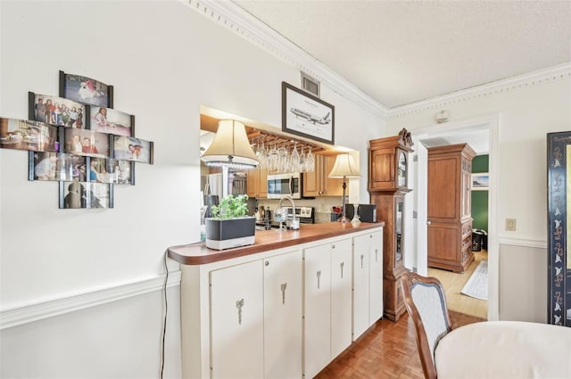 1050 Riverside Dr Unit A201, Palmetto, FL 34221 - kitchen with stainless steel appliances, ornamental molding, and white cabinetry