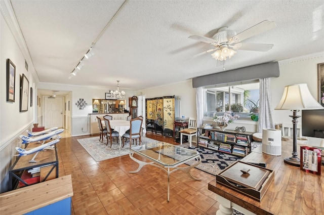 1050 Riverside Dr Unit A201, Palmetto, FL 34221 - living area featuring ornamental molding, a ceiling fan, a chandelier, a textured ceiling, and track lighting