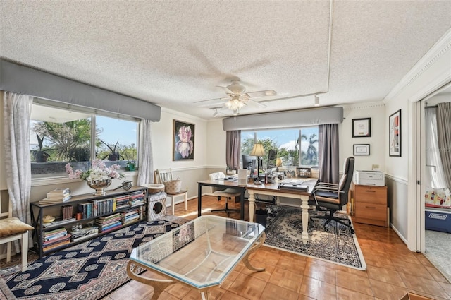 home office with ceiling fan, ornamental molding, a textured ceiling, and light tile patterned floors