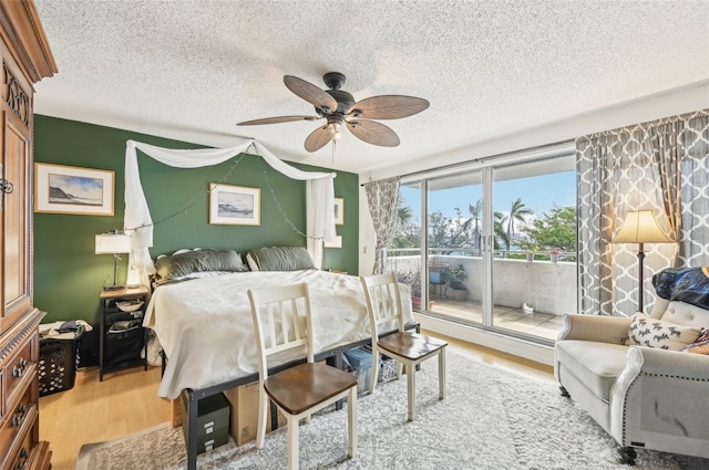 bedroom featuring hardwood / wood-style floors, ceiling fan, a textured ceiling, and access to outside