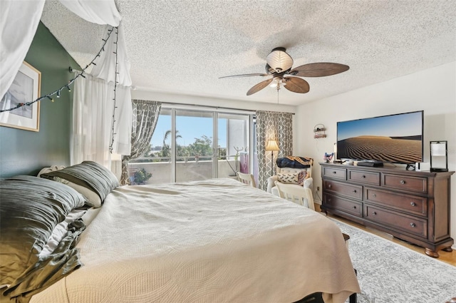 1050 Riverside Dr Unit A201, Palmetto, FL 34221 - bedroom with access to exterior, a textured ceiling, ceiling fan, and wood finished floors