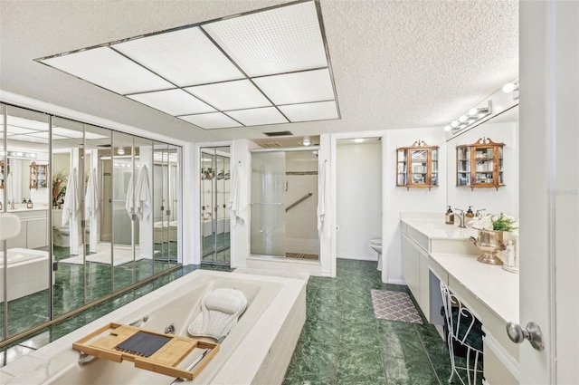 full bathroom featuring tile patterned floors, vanity, a textured ceiling, shower with separate bathtub, and toilet