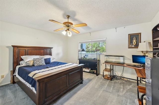 carpeted bedroom with ceiling fan and a textured ceiling