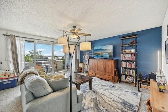 living room featuring ceiling fan, carpet, and a textured ceiling