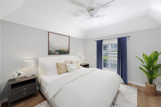 bedroom with a textured ceiling, hardwood / wood-style floors, and ceiling fan