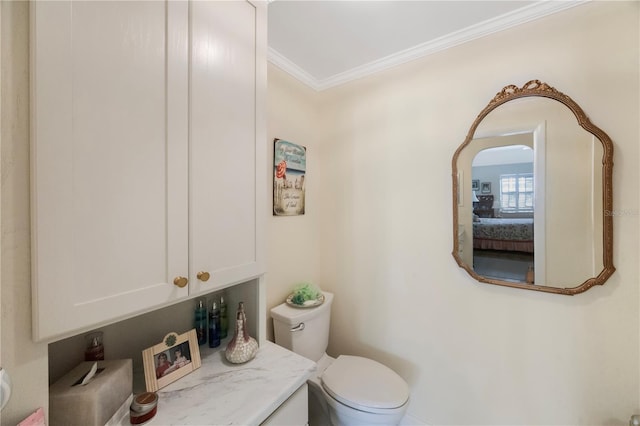 bathroom featuring toilet, vanity, and crown molding