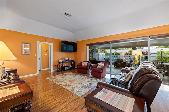 living room with light hardwood / wood-style flooring and lofted ceiling