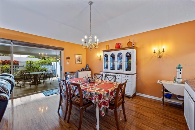 dining space with wood-type flooring and an inviting chandelier