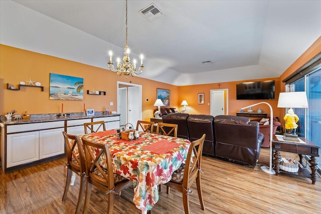 dining area with a notable chandelier and light hardwood / wood-style floors