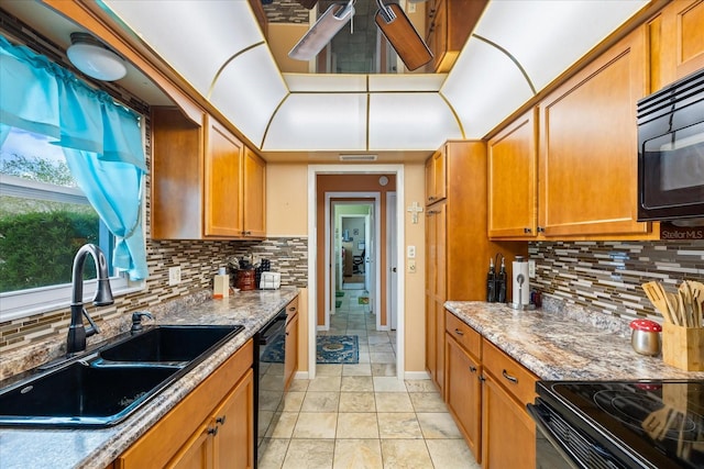 kitchen featuring sink, light stone counters, decorative backsplash, light tile patterned floors, and black appliances