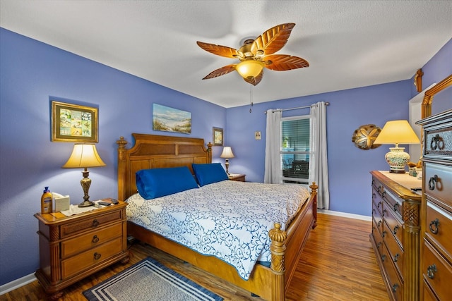 bedroom featuring ceiling fan, dark wood-type flooring, and a textured ceiling