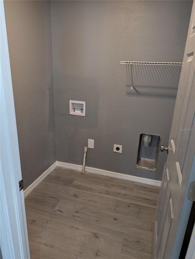 clothes washing area featuring hookup for a washing machine, light hardwood / wood-style floors, and hookup for an electric dryer