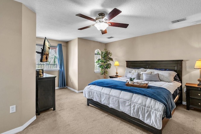 bedroom with visible vents, light colored carpet, a ceiling fan, and baseboards