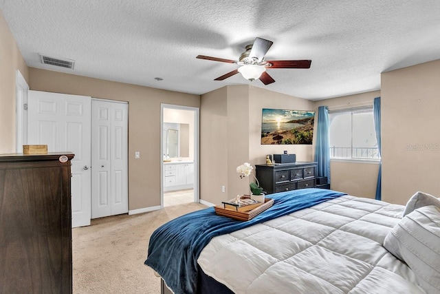 bedroom featuring visible vents, light carpet, a textured ceiling, connected bathroom, and baseboards