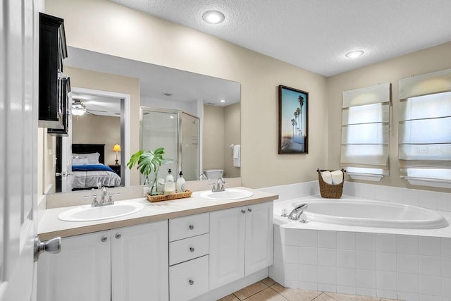 bathroom with a shower stall, a garden tub, ensuite bathroom, and a sink