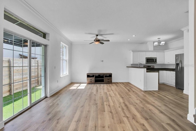 unfurnished living room with baseboards, light wood-type flooring, and ornamental molding