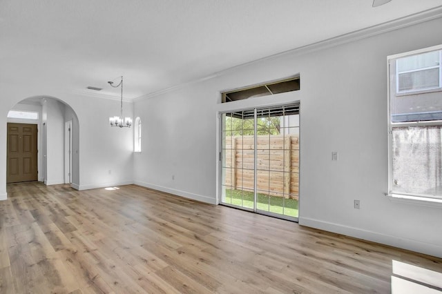 interior space with arched walkways, a chandelier, light wood-type flooring, and crown molding