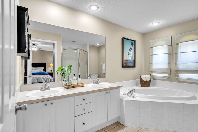 ensuite bathroom featuring ensuite bath, a bath, a shower stall, and a sink