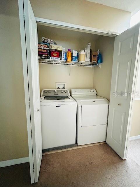 laundry area featuring washing machine and clothes dryer, laundry area, and baseboards